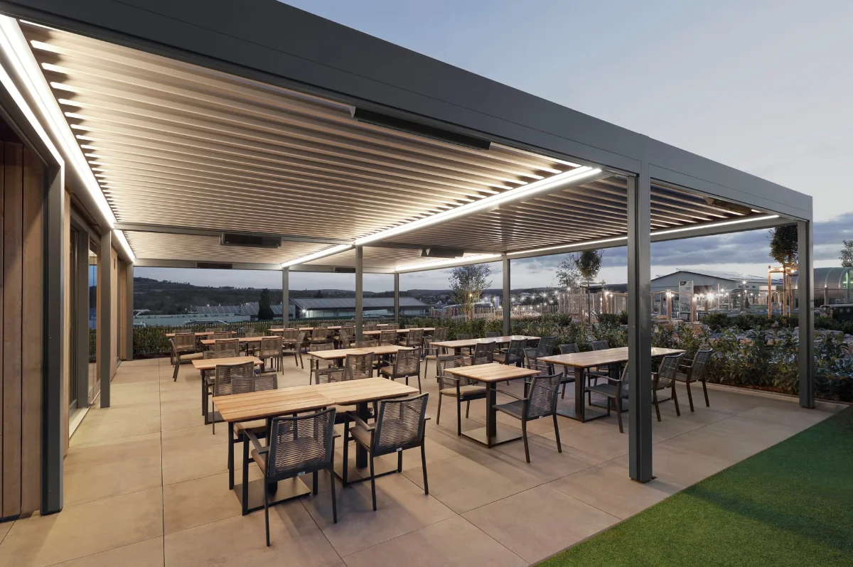 Moderne überdachte Terrasse in der Gastronomie bei Sonnenuntergang