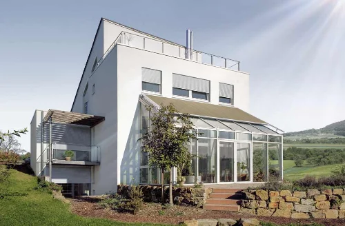 Weißes Haus mit Wintergarten und Markise