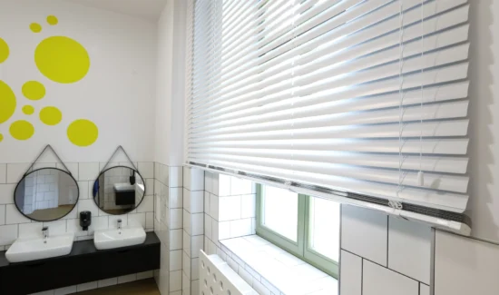 Moderne Badezimmergestaltung mit weißen Jalousien und stilvollen Spiegeln